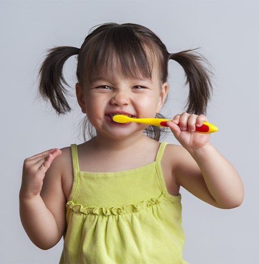 Young girl practicing tooth brushing