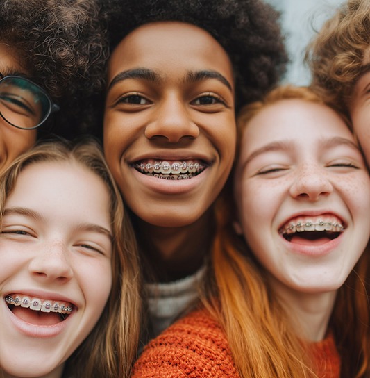 Group of teens with braces smiling taking selfie
