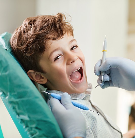 Little boy having his teeth checked by dentist
