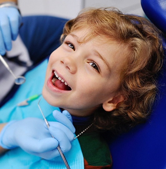 A little boy having his teeth checked and cleaned during a regular visit