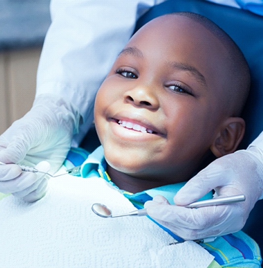 A young girl smiles in preparation for his pulp therapy treatment