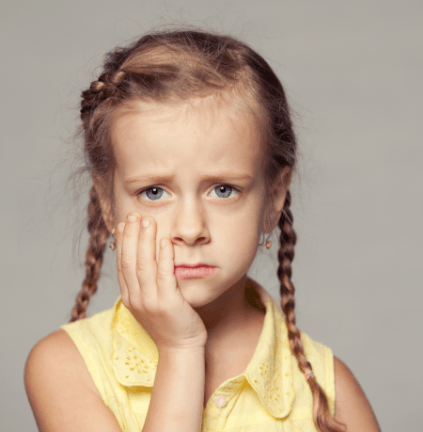 Little girl with bitten cheek holding jaw