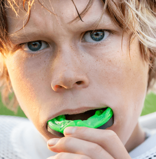 Teen boy placing sports mouthguard