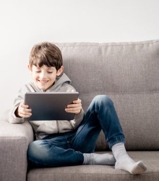 Smiling boy looking at his tablet computer