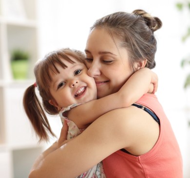 Mother giving her daughter a hug at dental office