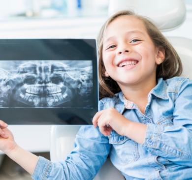 Little girl holding up tablet digital x-rays