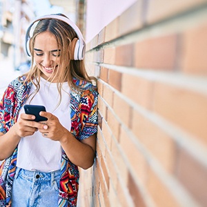 Teen girl smiling while listening to music outside