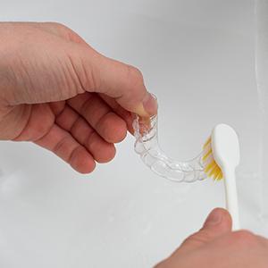 Patient cleaning clear aligner with toothbrush