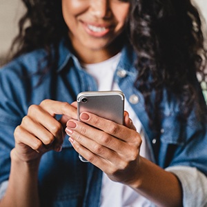 Teen smiling while looking at phone