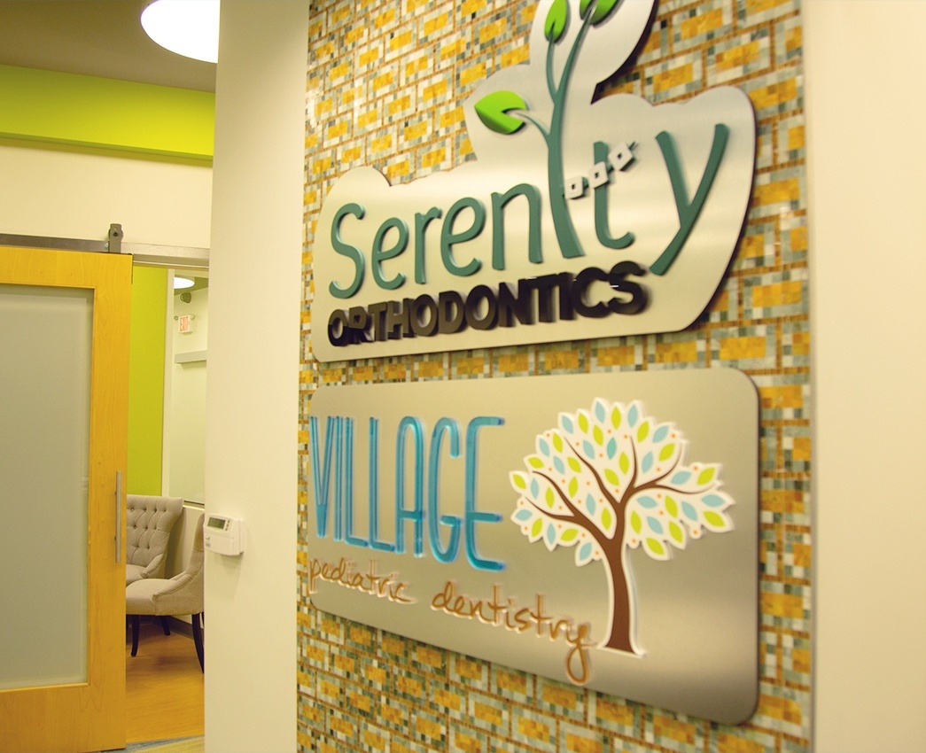 Serenity Orthodontics and Village Pediatric Dentistry signs on dental office wall