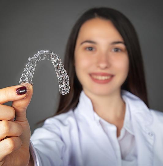 Teen girl holding an Invisalign tray