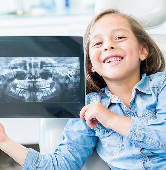 Little girl holding up tablet with her digital x-rays