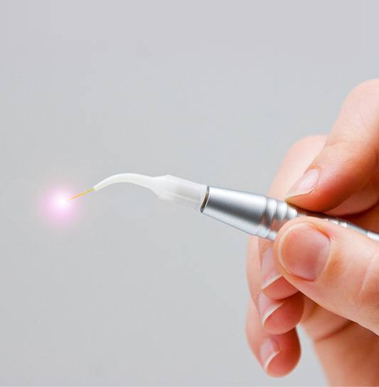 Hand holding a soft tissue dental laser
