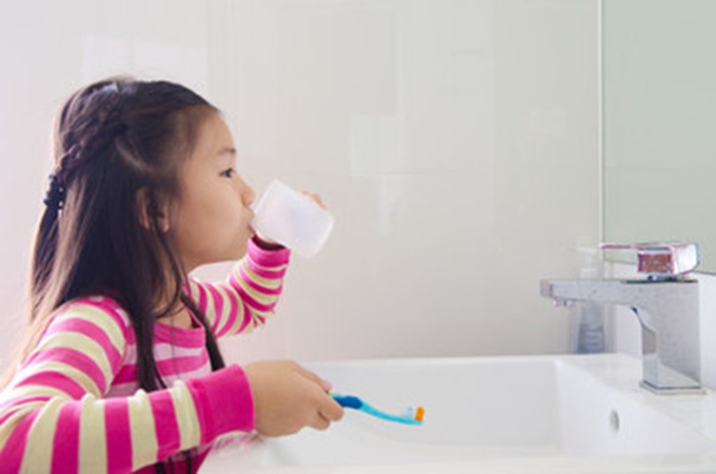 Young girl brushing her teeth.