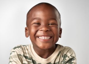a child is showing his beautiful, healthy smile