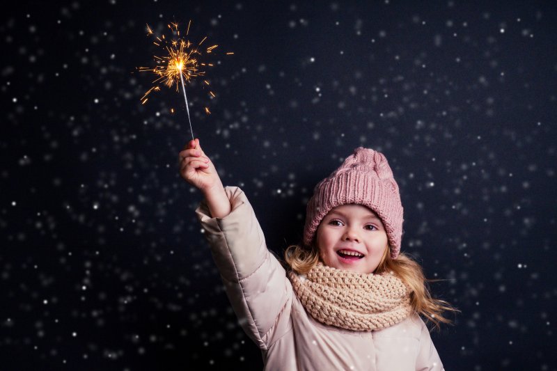 smiling child holding a sparkler