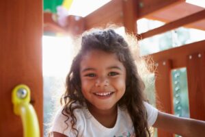 Kid smiling on playground. 